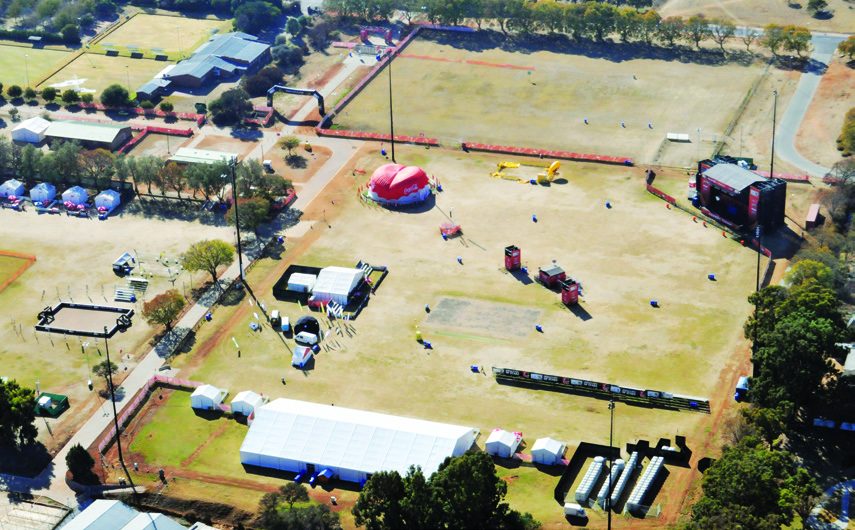 Aerial view of the fan park grounds with marquees and tented areas among trees.