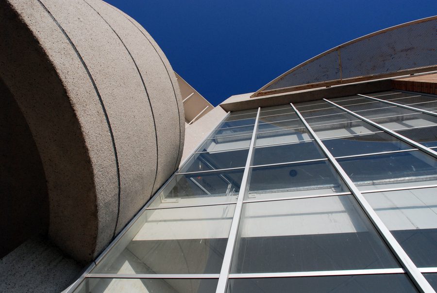 Curved concrete balcony band and glazed facade, seen from below.