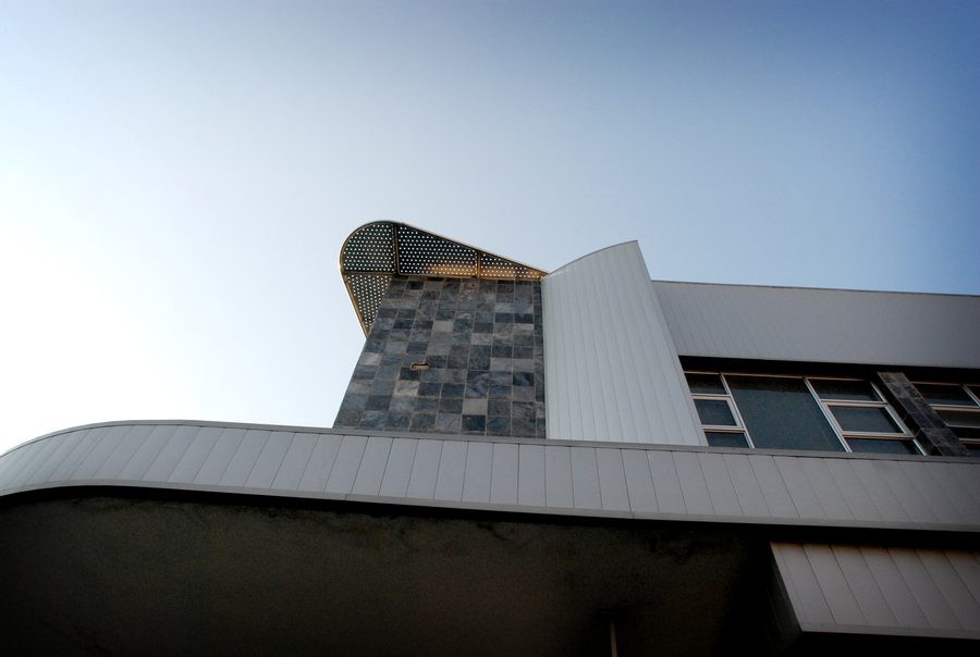 Stone-clad feature and curved canopy edge, seen from below against the sky.