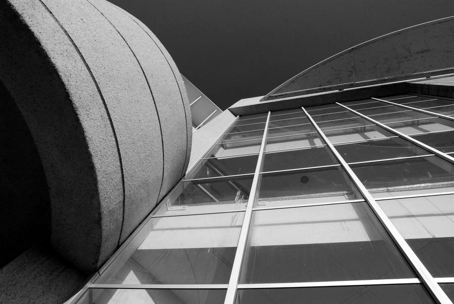 Glazed atrium roof and curved concrete canopy, seen from below.
