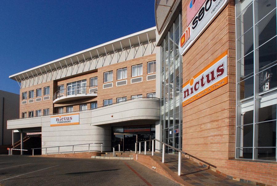 Street view of the face-brick office building with a curved entrance canopy and glazed atrium.