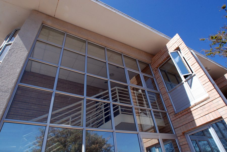Glazed stair bay with a steel balustrade, face-brick walls and a projecting roof.