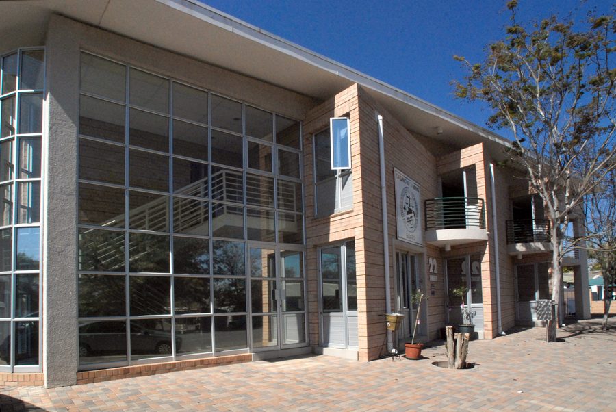 Glazed stair bay and paved forecourt of the two-storey office building.