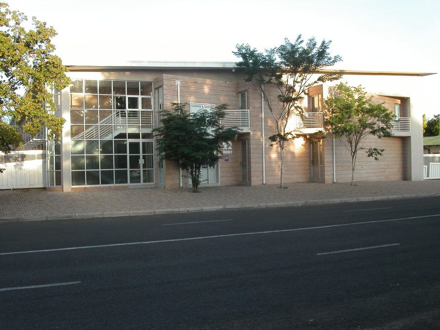 Street elevation of the two-storey office building with a glazed stair bay and trees along the frontage.