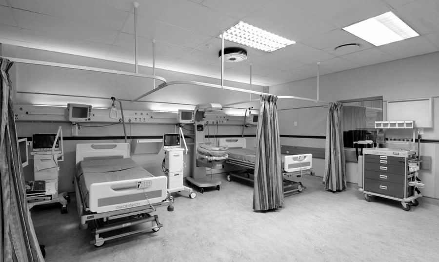 Ward with hospital beds, curtains and bedside equipment.