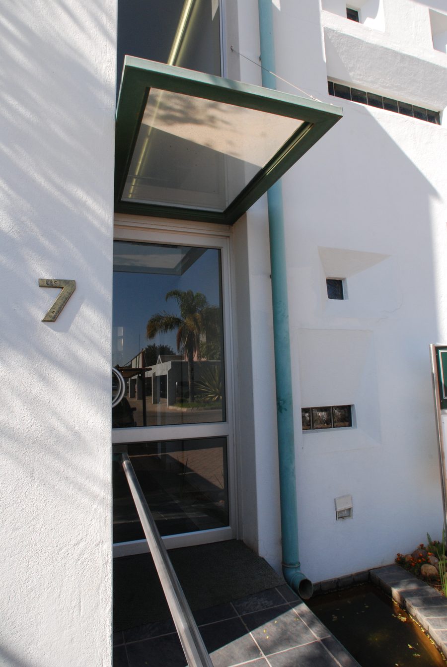 Entrance with a glass canopy and the number 7 on the wall.