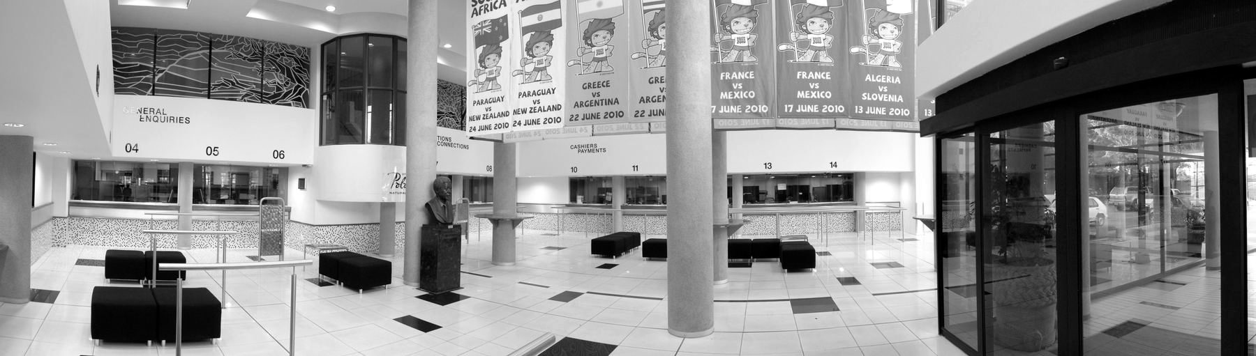 Public hall with a high ceiling, service counters and hanging banners.